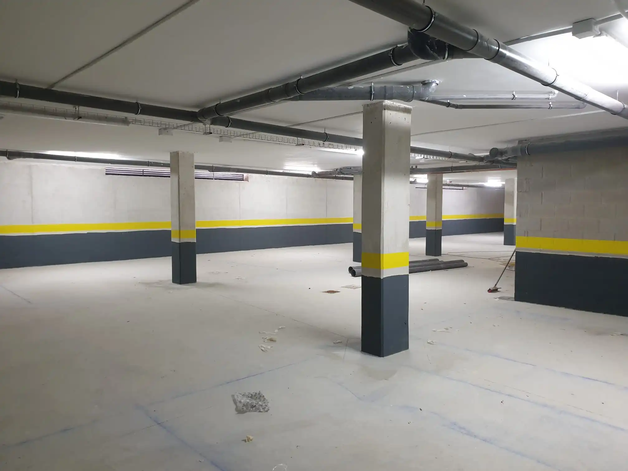 Operario pintando paredes de garaje en gris y amarillo en Zaragoza